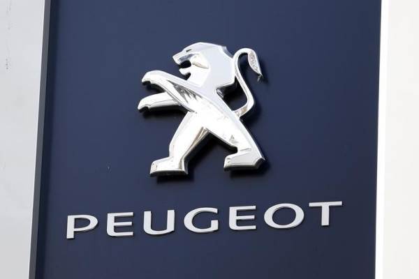 A Peugeot company logo is seen outside an automobile dealer